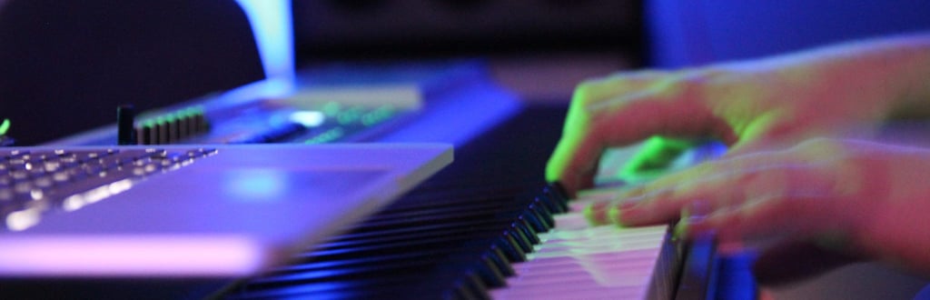 a person playing e-piano with a laptop