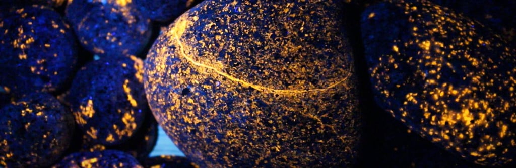Orange glowing yooperlite rocks under 365nm uv light.