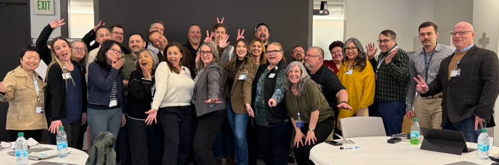 Providence Supply Chain colleagues posing for a fun team photo in a conference room.