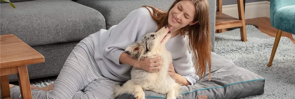 a woman sitting on a dog bed with her dog