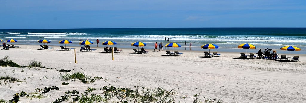 tour to daytona beach with people sitting on chairs and umbrellas