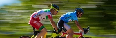 two men riding bikes on a road