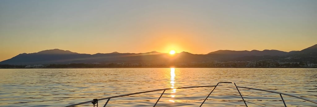 a boat in the water with the sun setting