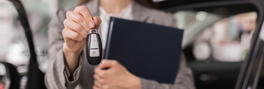 Expat holding car keys and documents for vehicle registration process in Spain with insurance