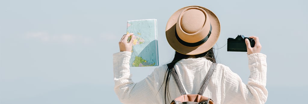 a woman in a hat and a backpacker holding a map