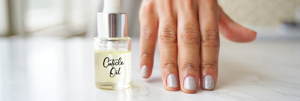 mano con unghie glitterate con applicato l'olio per cuticole raffigurato di fianco nella boccetta 
