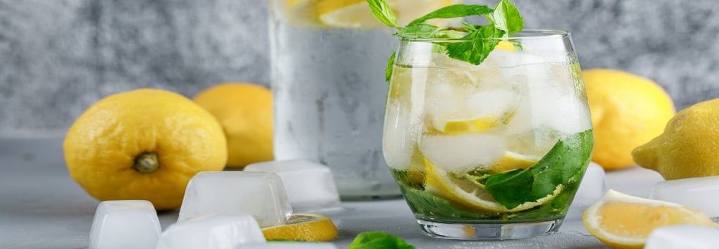 Lemonade in a glass and Lemons with ice cubes