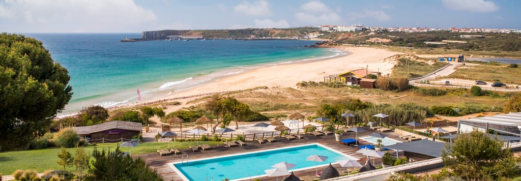 Luxury resort Martinhal Sagres with an outdoor swimming pool overlooking a sandy beach and ocean