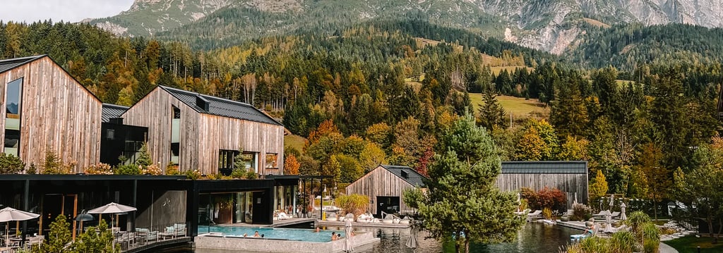 Luxury mountain resort with outdoor heated pool and wooden chalets nestled in the Alps.