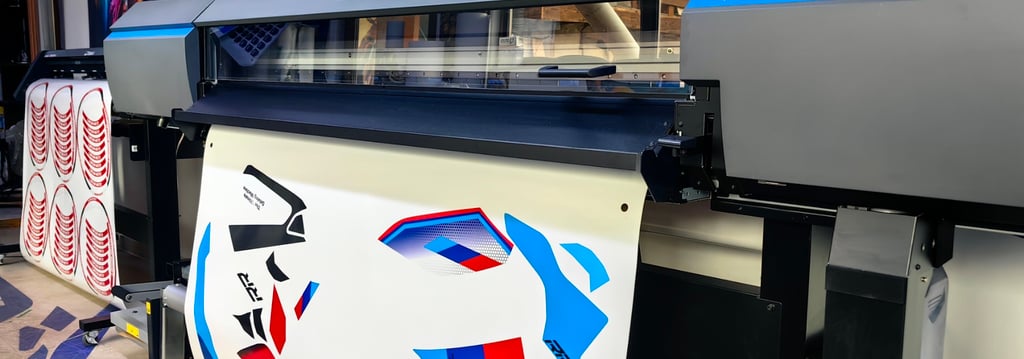 Roland TrueVIS wide format inkjet printer printing custom vinyl vehicle decals in a professional print shop.