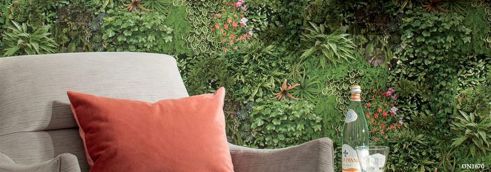 Modern living room featuring a vertical garden wall behind a grey armchair with an orange cushion.