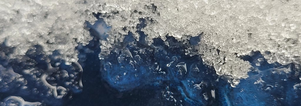 close up picture of ice melting off a blue metal surface