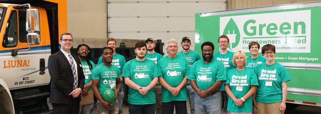 Green Homeowners United team picture, people wearing green shirts and smiling