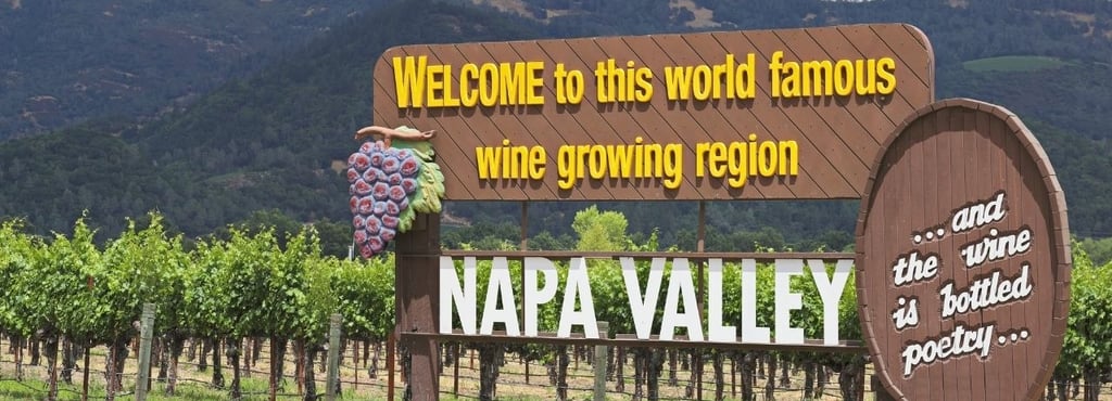 Placa de boas-vindas em Napa Valley com vinhedos ao fundo, Califórnia.