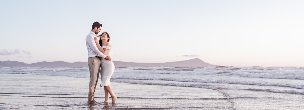 a man and woman standing in the ocean