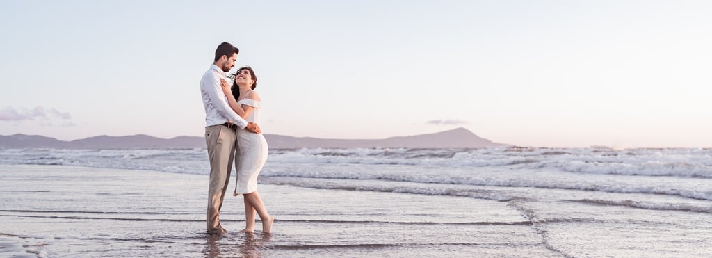 a man and woman standing in the ocean