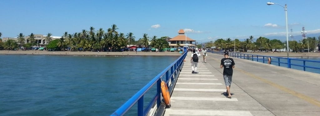 Vista do navio ancorado em Puntarenas, Costa Rica, com pier e cidade ao fundo