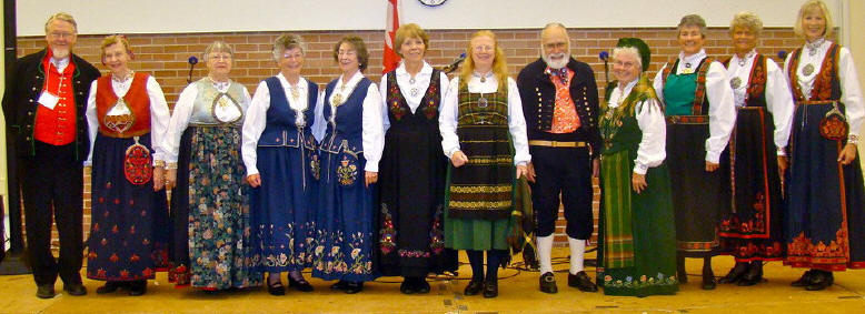 2 men and 10 women wearing bunad at a stevne