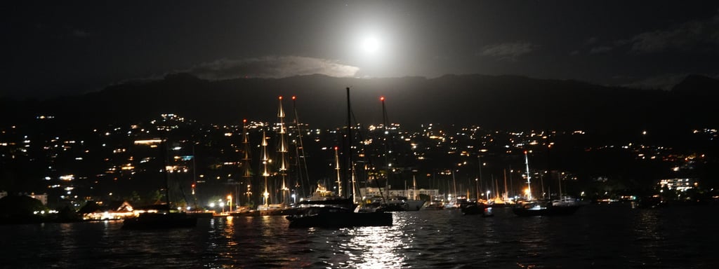 Night view of Tahiti with sailboats and shining moon