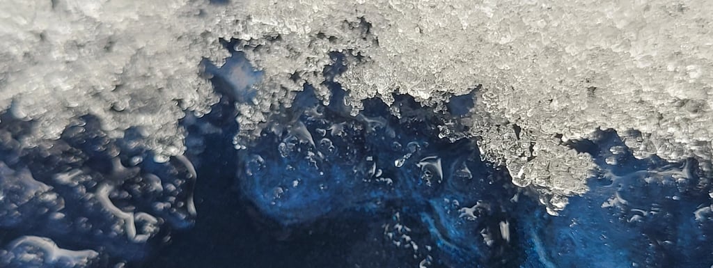 close up picture of ice melting off a blue metal surface
