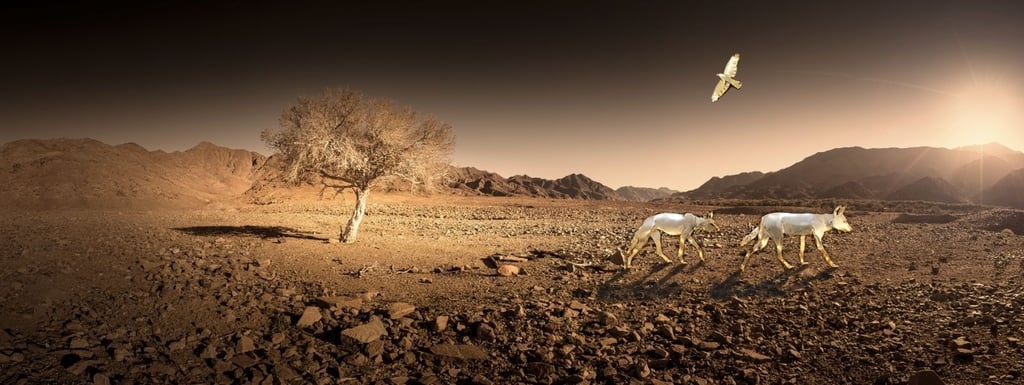 Sculpted golden antelope and soaring bird set against a panoramic desert landscape with a single tree and mountain backdrop,