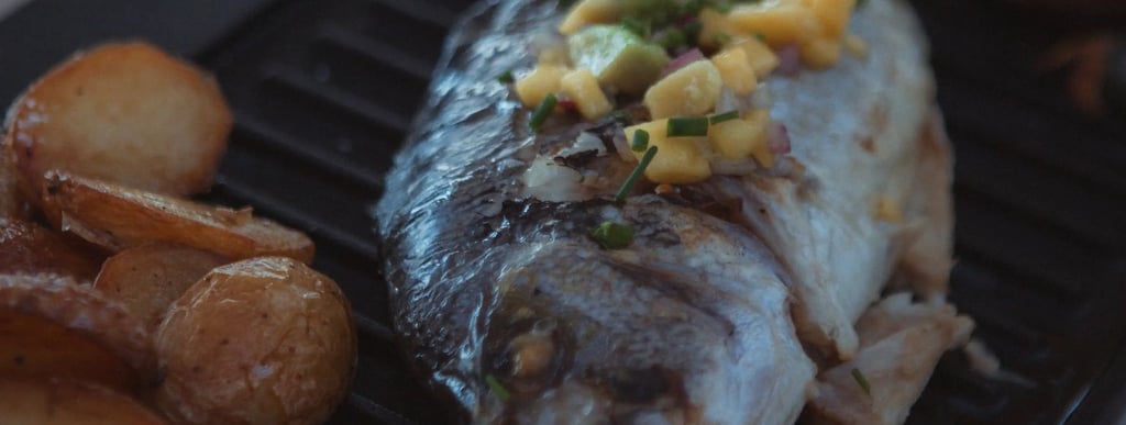 Poisson frais grillé accompagné de pommes de terre et légumes de saison