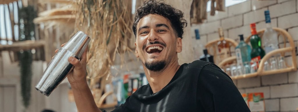 Barman en pleine préparation d’un cocktail signature au bar de Playa Amor