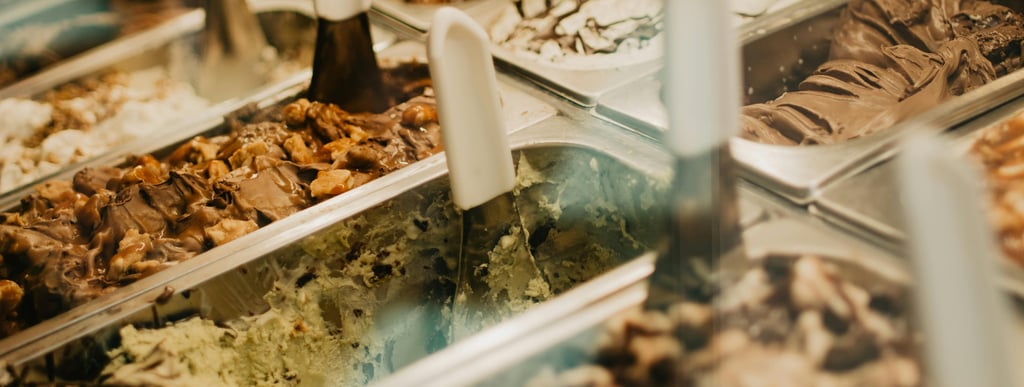 a variety of ice creams in an ice cream shop window.