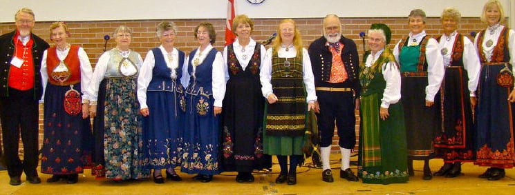 2 men and 10 women wearing bunad at a stevne