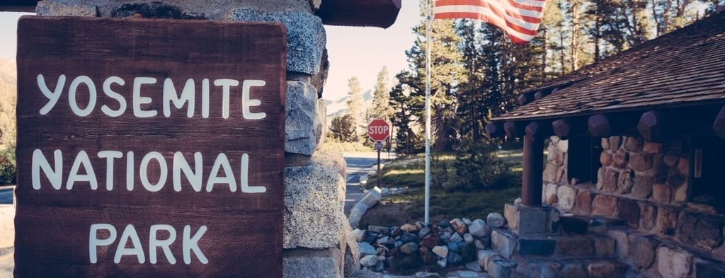 Entrada principal do Parque Nacional de Yosemite com paisagem montanhosa ao fundo.