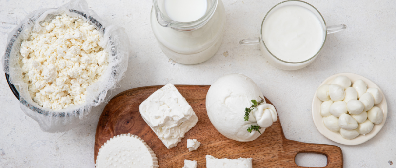 Une planche à découper avec du lait et différents types de fromage