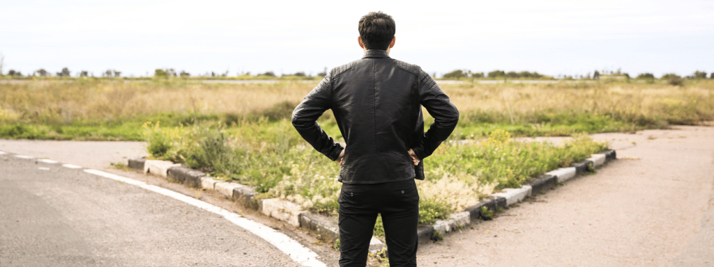 a man in a suit and tie standing on a road