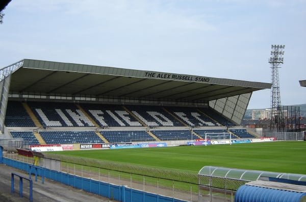 Innenansicht des Windsor Park in Belfast mit Blick auf die Haupttribüne, leuchtend blauen Sitzreihen und dem Spielfeld im Vor