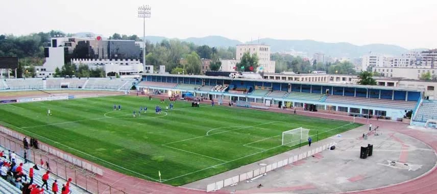 Selman-Stërmasi-Stadion in Tirana aus der Vogelperspektive, Blick auf Spielfeld, Tribünen und umliegende Stadtviertel