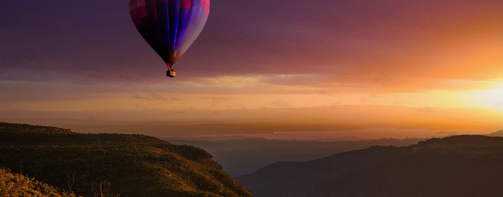 hot air balloon flying over a canyon at sunrise