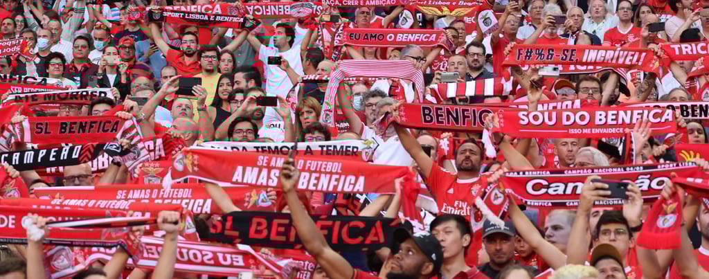 Leidenschaftliche Benfica-Fans singen im Stadion, rote Schals in der Luft, Gänsehaut-Stimmung