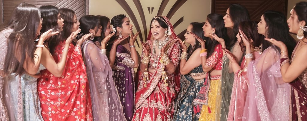 an indian bride with group of girls having flying kisses