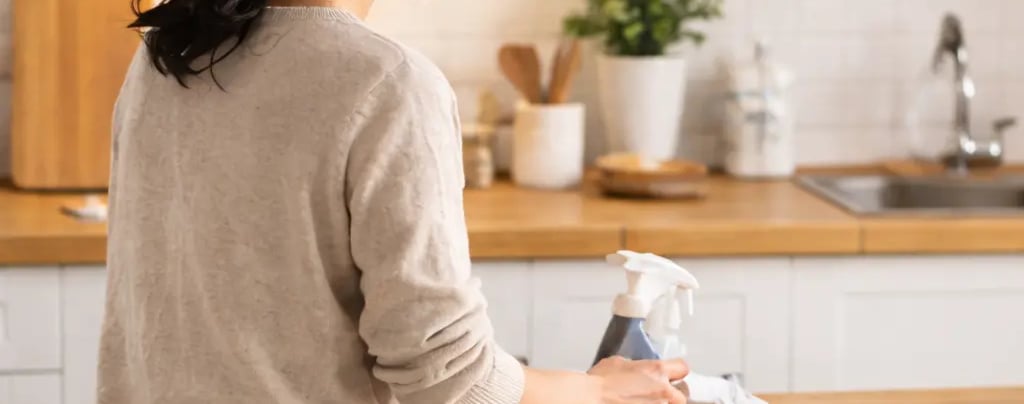 Wiping a kitchen counter during a daily reset routine to keep the home clean