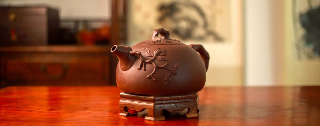 Teapot with an accentuated design placed on a wooden stand