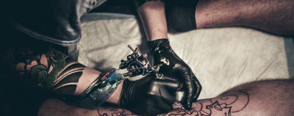 a man is getting a tattoo on his arm