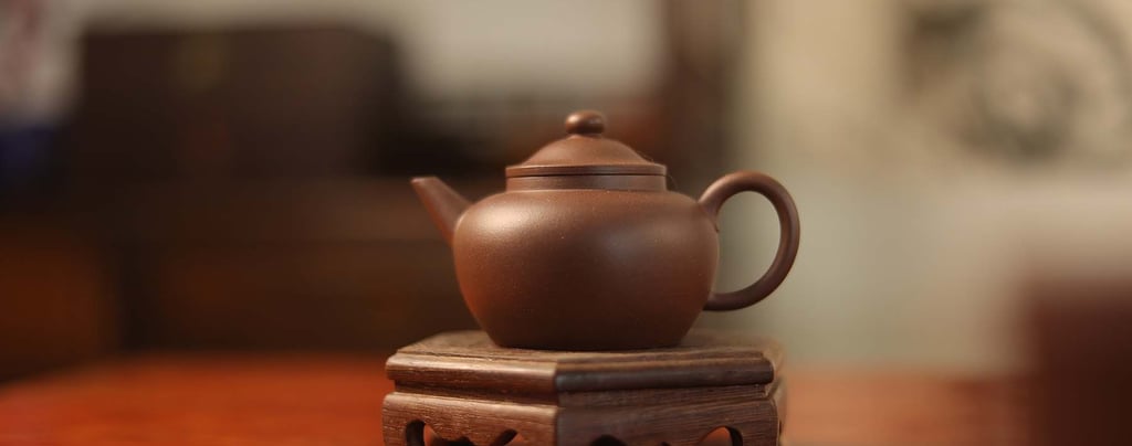 Brown teapot placed on a wooden stand