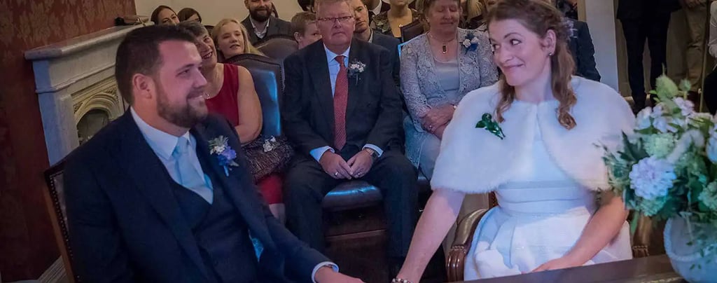 Newly weds holding hands in the Garden Room in Southwark Registry Office