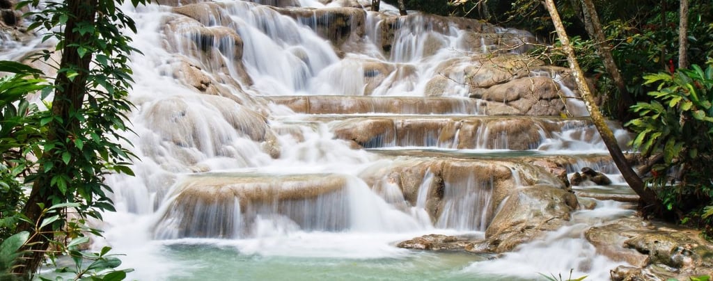 Cataratas Dunn’s River na Jamaica, com cascatas em degraus rodeadas por vegetação tropical