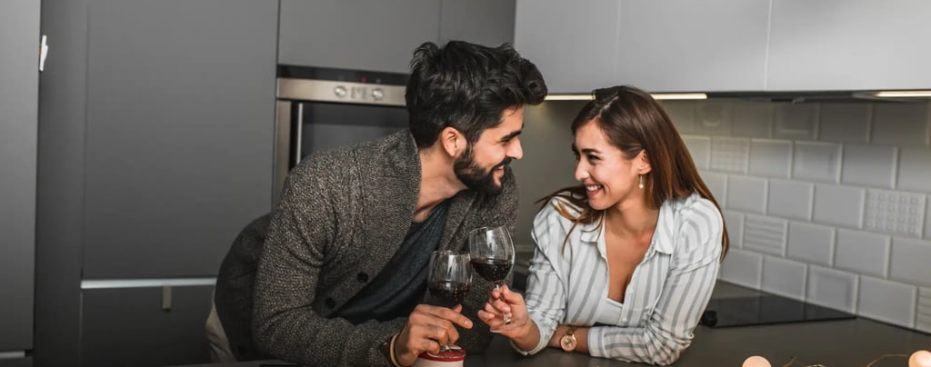Pareja feliz celebrando su aniversario con una copa de vino escuchando una canción personalizada de Musycol.