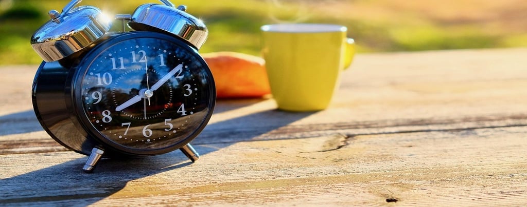 Alarm clock and Tea Cup on the Table