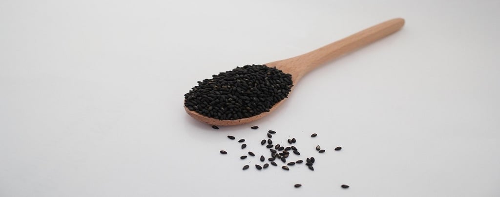 Black Sesame Seeds on a wooden spoon
