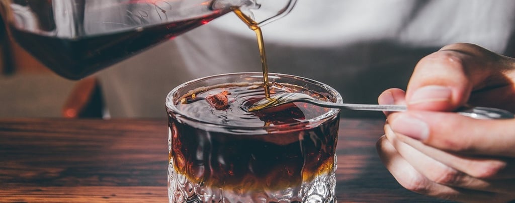 Pouring coffee in a glass cup