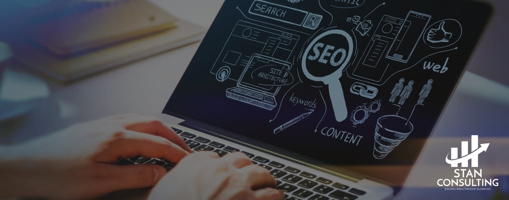 a person sitting at a desk with a laptop and performing SEO