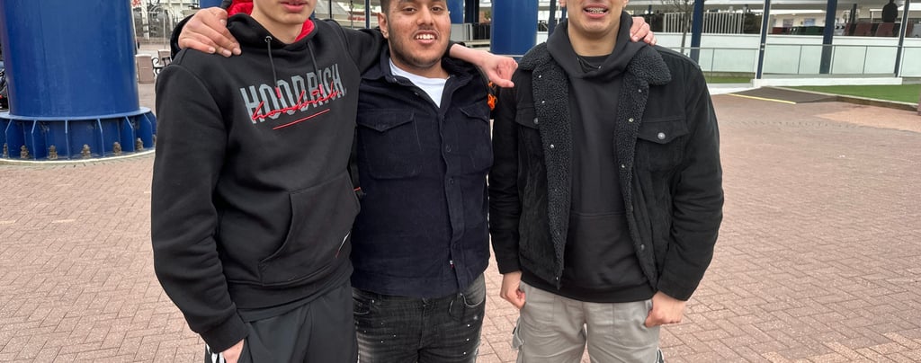 three men standing next to each other in front of a building