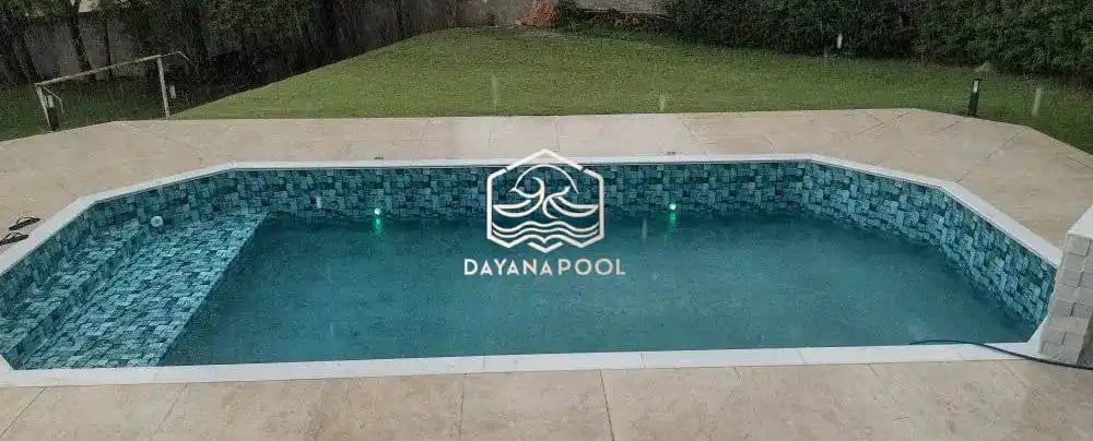 kolam renang sederhana di halaman belakang rumah dengan keramik berwarna biru tua
